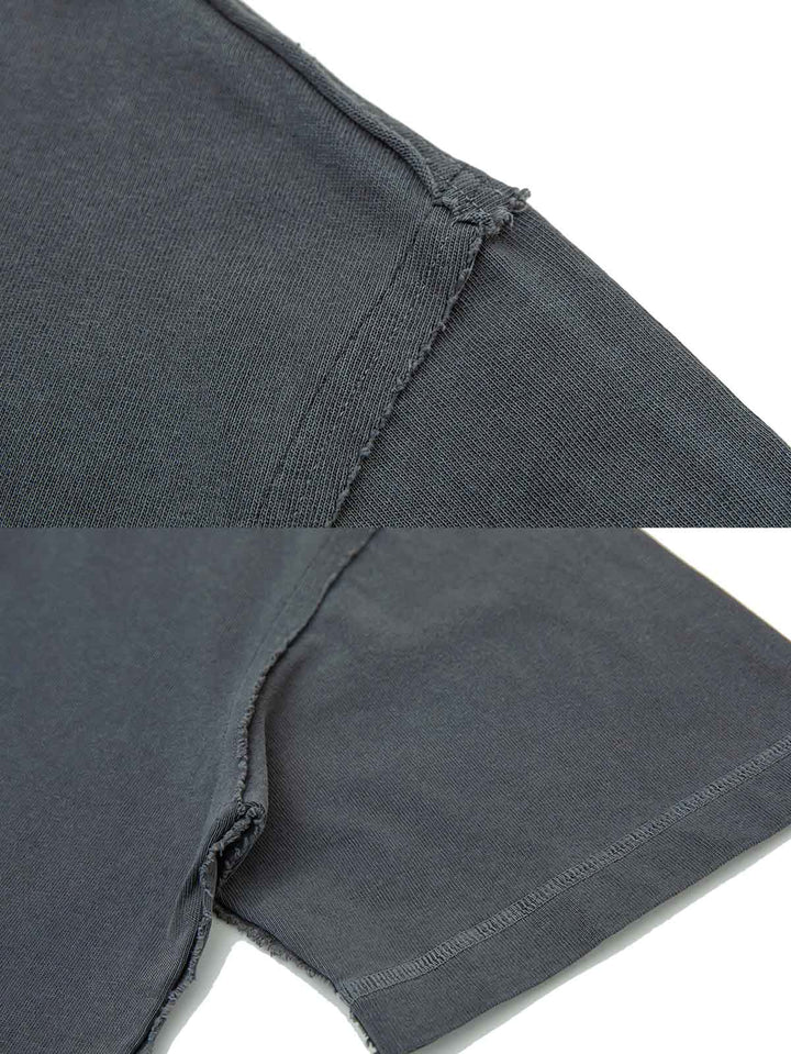ウォッシュ加工ヘビーウェイトTシャツの細部にわたる精巧なエッジ処理のクローズアップ。