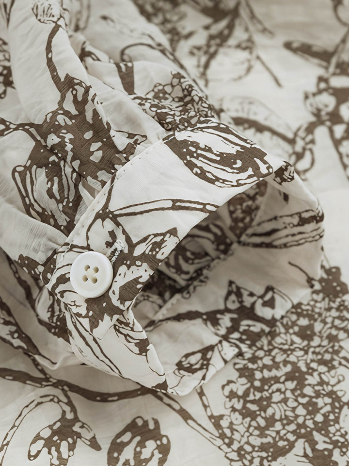 詳細画像: ツタ柄シフォン長袖シャツの詳細図。ツタ柄プリントと半開襟のデザインを展示。