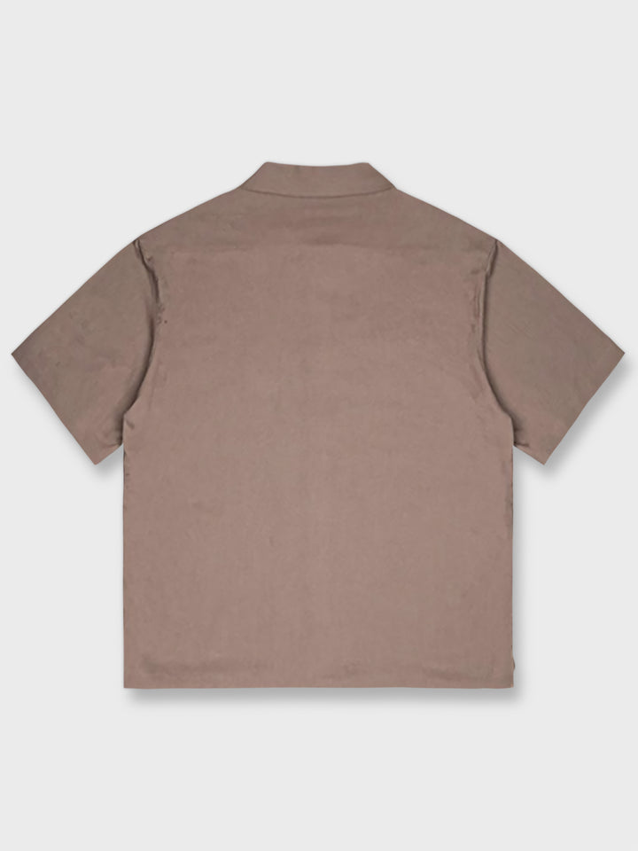キューバカラーのコットンリネン短袖シャツのフロントビュー。自然なしわ感のあるコットンリネン素材と胸元のプリント装飾が特徴。
