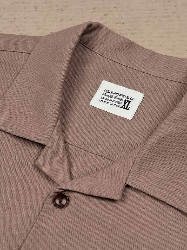 キューバカラー短袖シャツの繊細なポケットデザインと胸元のプリント部分のクローズアップ。実用性と洗練されたスタイルが見て取れる。
