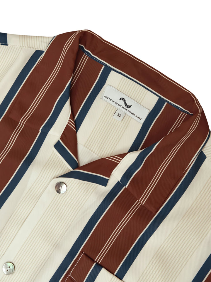 ストライプハワイアンシャツのシングルブレストのボタン留めとフロントポケットの詳細。通気性のある軽量生地が使用されており、カジュアルながら整然とした印象を与えるファッショナブルなデザインです。