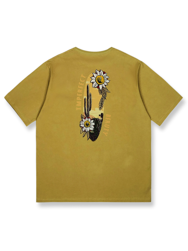 デザートイエローの背景にサボテンと野生の花の刺繍が施された「デザートフラワー」半袖Tシャツの正面ビュー。ゆったりとしたフィット感で、夏の日常着に理想的です。