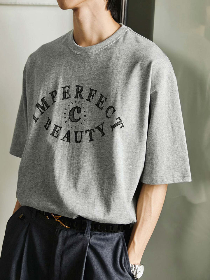 ディスカバリーの目」テーマの純綿Tシャツを着用したモデルが、カジュアルなスタイルで着用する様子を披露しています。