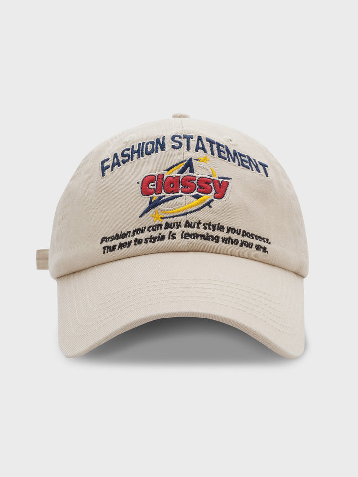 「FASHION STATEMENT CLASSY」と刺繍された野球帽の正面ビュー。クラシックなデザインと現代的なメッセージが融合した帽子、背景は白くシンプル。