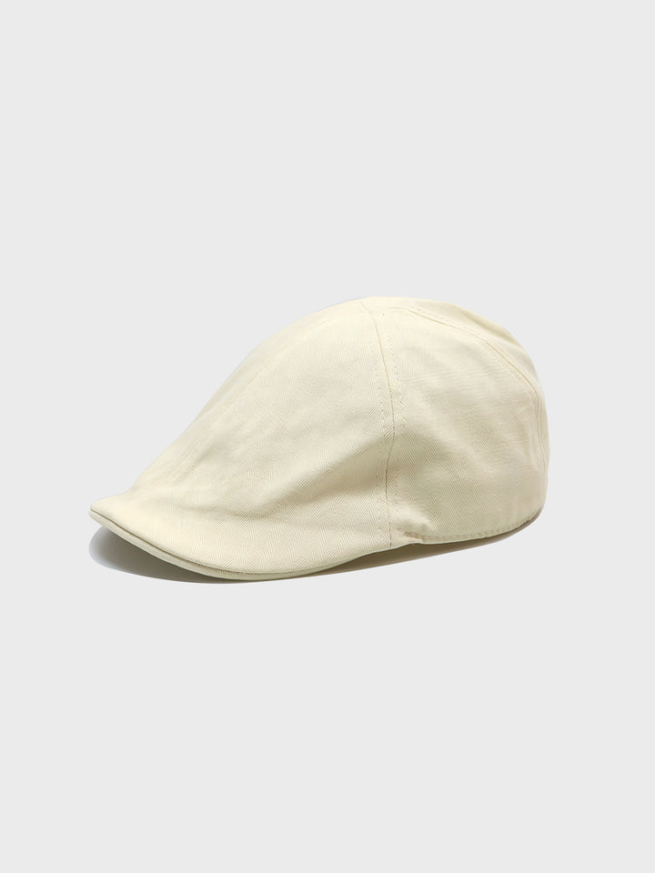 上品なピュアコットン製ベレー帽が中央に置かれており、シンプルなデザインと精緻なステッチが特徴的です。