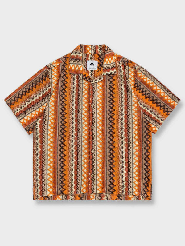 1950年代のアメリカンヴィンテージスタイルにインスパイアされたキューバカラーの立体編みシャツの全体ビュー。独創的な幾何学的パターンが特徴で、リラックスフィットと透気性のあるポリエステル生地が快適な着心地を提供します。