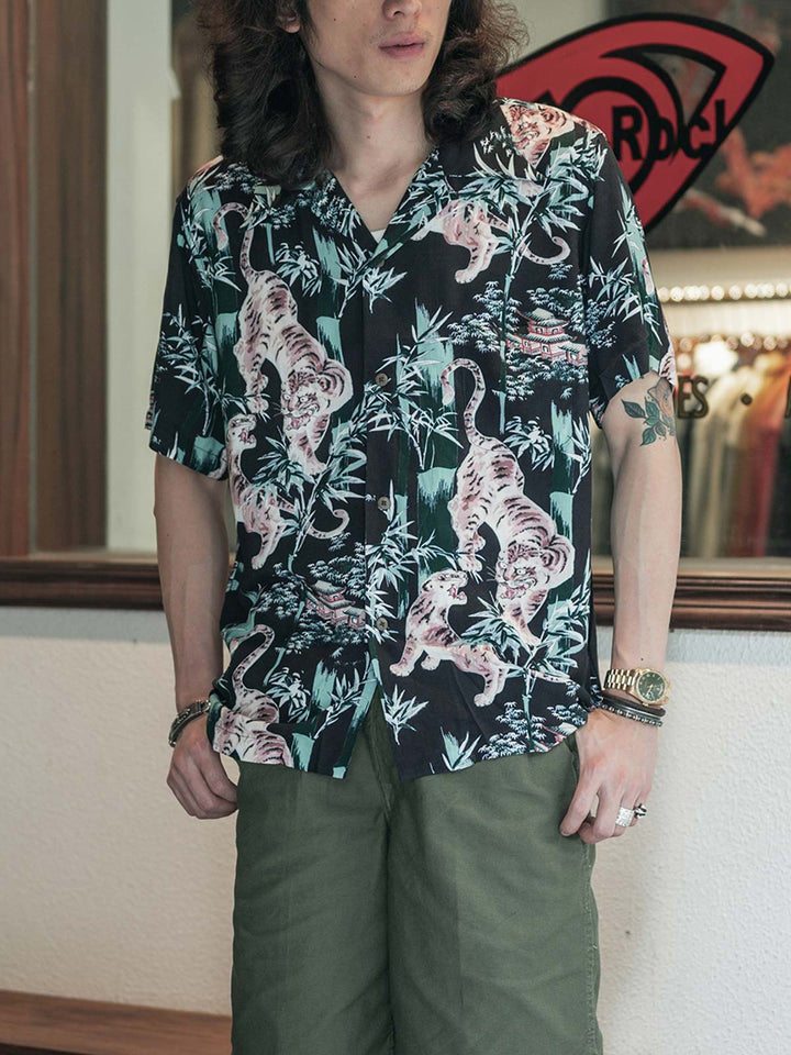 モデルが浮世絵竹林タイガー柄キューバカラー半袖シャツを着用し、スタイリッシュでカジュアルな装いを披露しています。