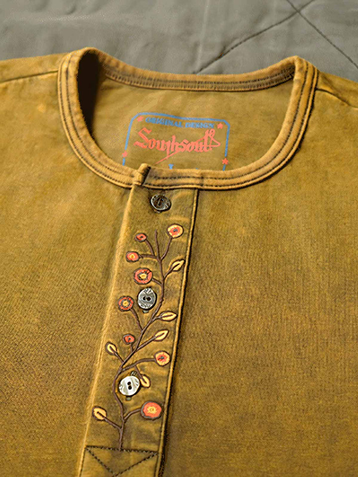 ヘンリーネックシャツの襟元と袖口の詳細。高品質のスレッド技術とカスタムリブが特徴です。