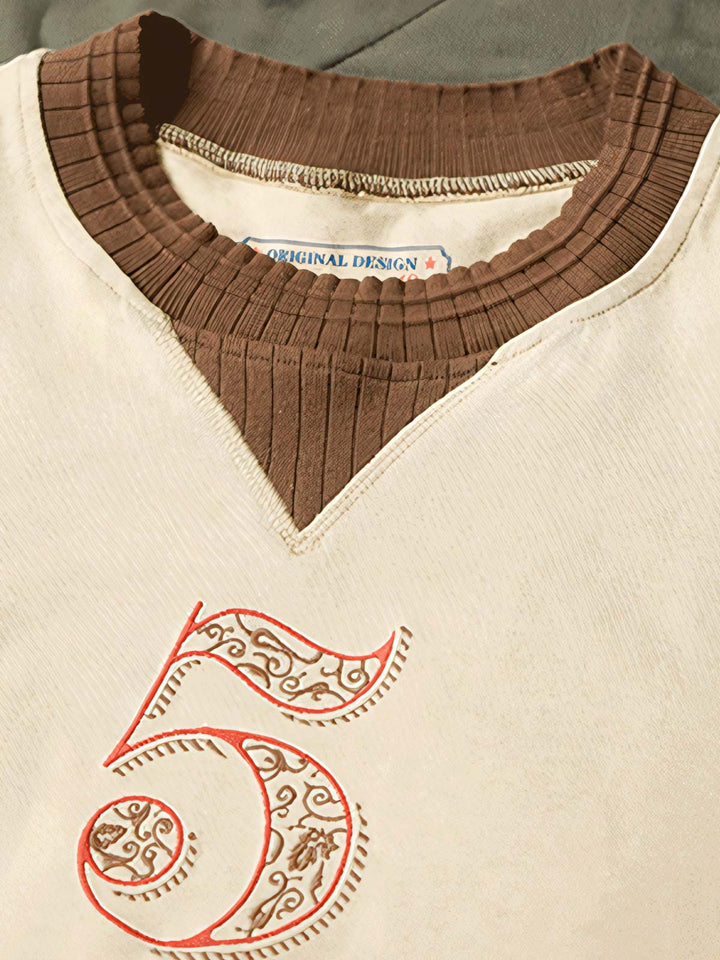 Tシャツの刺繍パターンとリブデザインのディテールクローズアップ