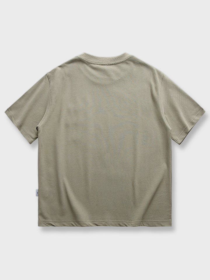 アーミーグリーンのピュアコットンTシャツ、胸部に英字の刺繍入り。