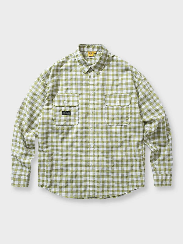 明るいグリーンのチェック柄が特徴のカジュアルシャツ。胸ポケットに小さなブランドタグがアクセントとして付けられ、フレッシュで活動的な印象を与える。
