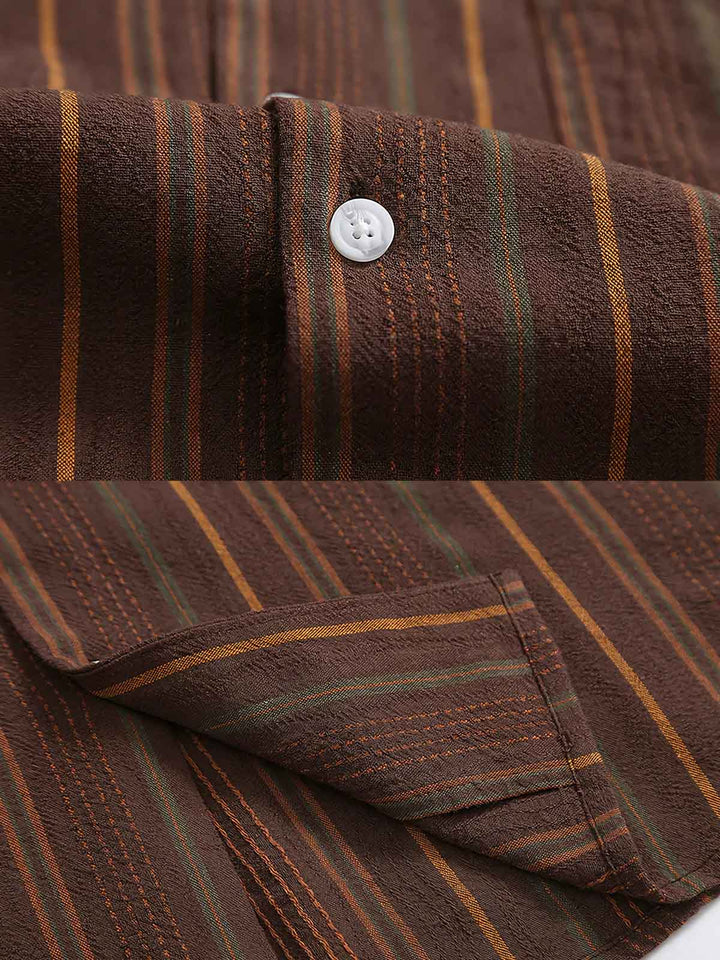 シャツのフロント部分と縦ストライプパターンの詳細クローズアップ。繊細な織り技術によるパターンの鮮明さと軽量のコットンブレンド素材が、通気性と快適性を提供します。フロントポケットが実用性を高め、デザインの清潔感を保っています。