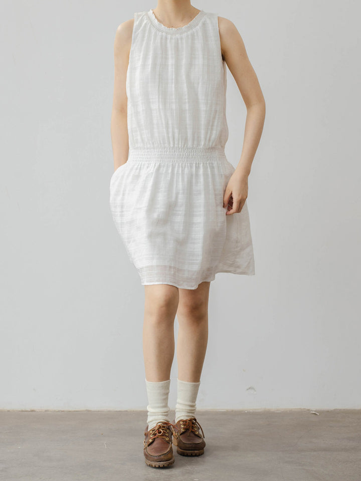 モデル画像: モデルが着用するフレンチレトロなシャーリングホワイトコットンタンクドレスの着用効果