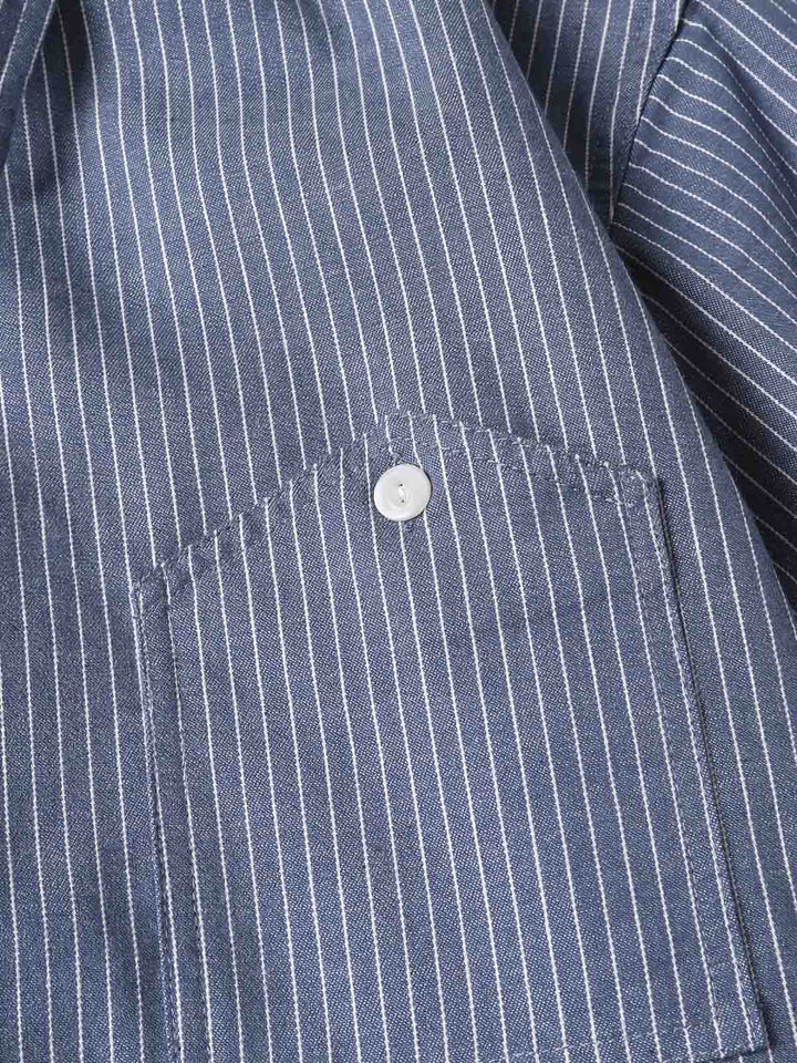 シャツの非対称ポケットと縦ストライプパターンのクローズアップ。70%コットンと30%ポリエステルの混紡ファブリックが見える。