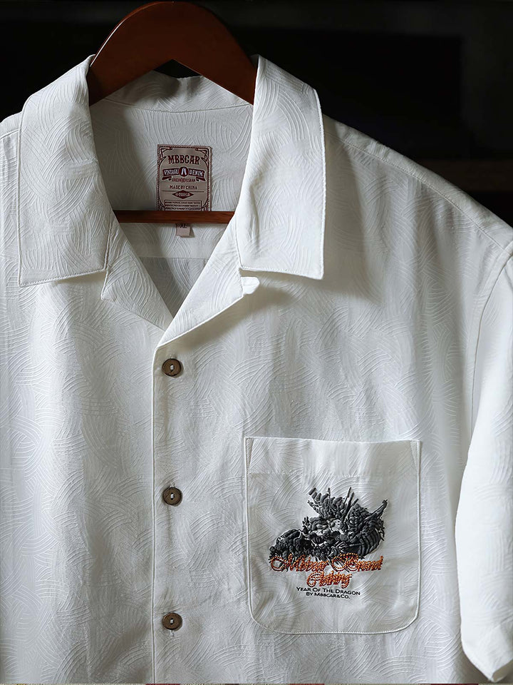 細部にわたるドラゴンの発泡プリント刺繍を特徴とするシャツのクローズアップ。