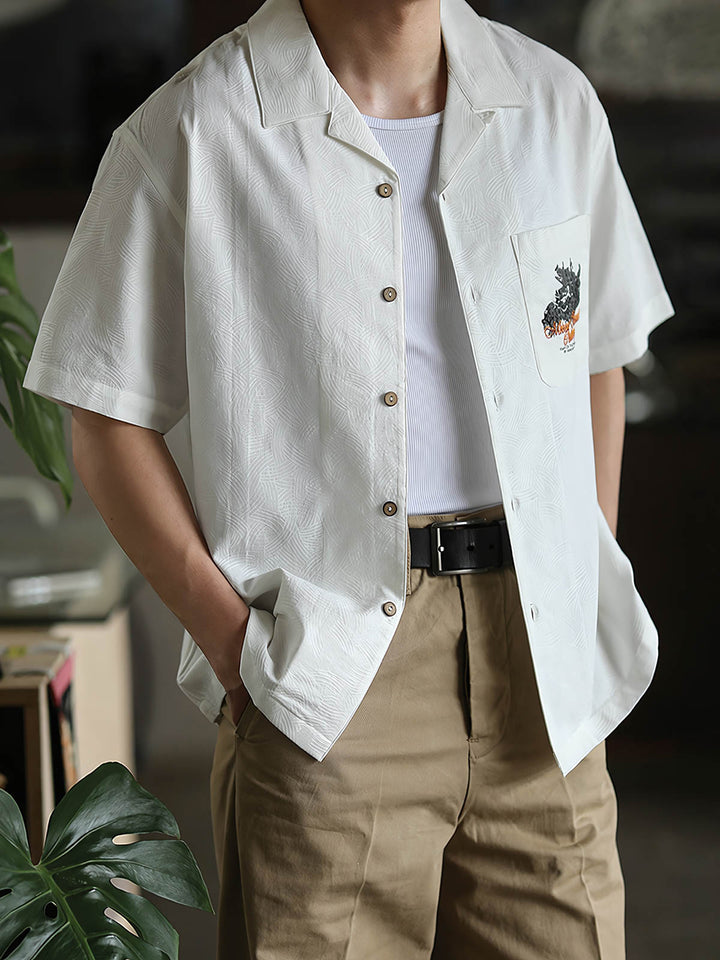 モデルがリネンパンツと合わせて着用するスカルドラゴン刺繍キューバンシャツ。
