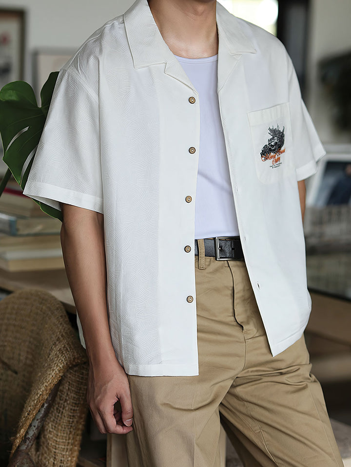 モデルがリネンパンツと合わせて着用するスカルドラゴン刺繍キューバンシャツ。