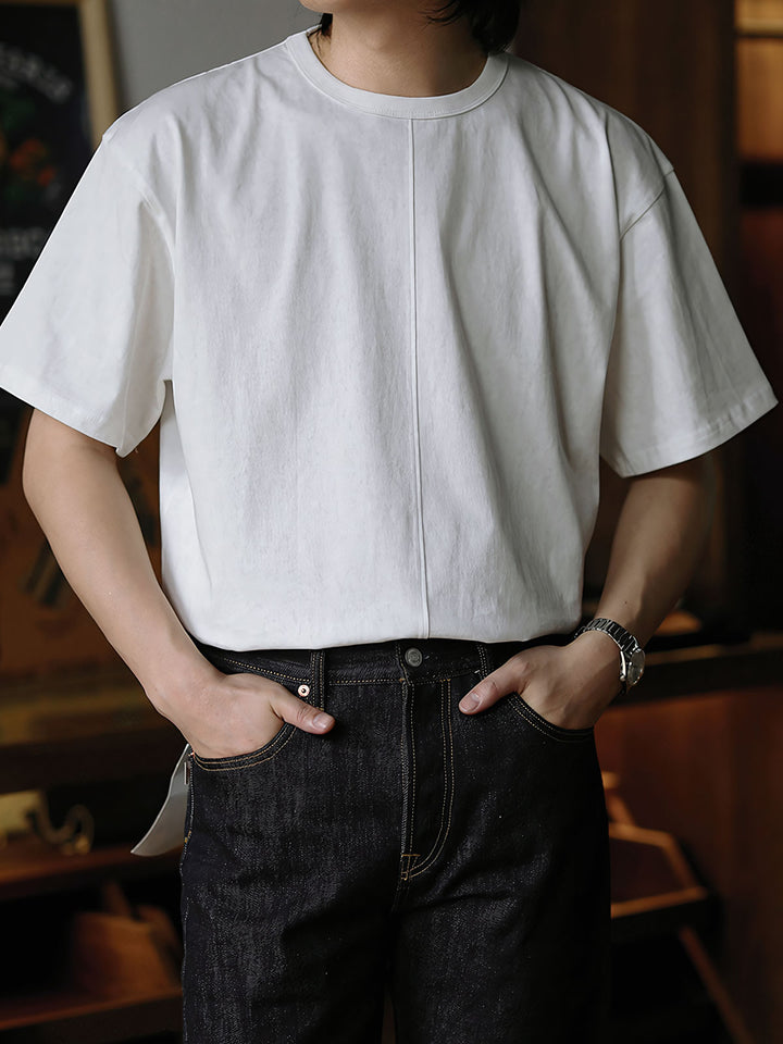 モデルがリラックスフィットのボックス型シルエットのワックスダイマーブル加工ショートワイドTシャツを着用し、カジュアルシューズと組み合わせたコーディネートを披露。デニムとの相性が良いスタイル。