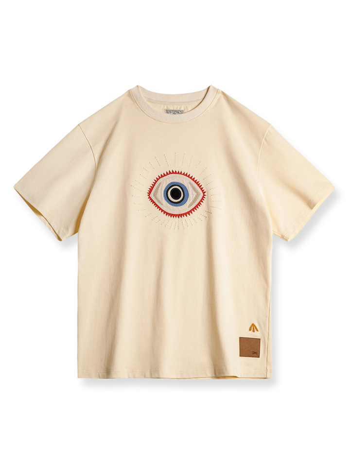 「守護の眼」の刺繍の詳細が映えるショートスリーブTシャツの正面画像。