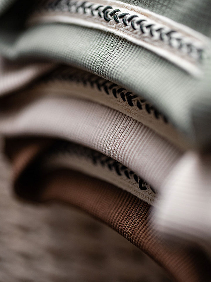 ワッフル柄ワイドフィット半袖Tシャツのクルーネックと袖口の詳細クローズアップ。細かい仕上げが施されたデザインで、洗練された印象を与えるとともに、耐久性と快適性を向上させています。