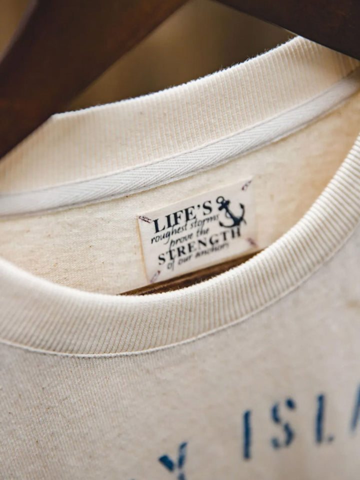 Tシャツの詳細なプリントと綿の殻入りのコットン生地のクローズアップ。環境保護を考慮した素材使用で、独特の質感と着心地を提供します。