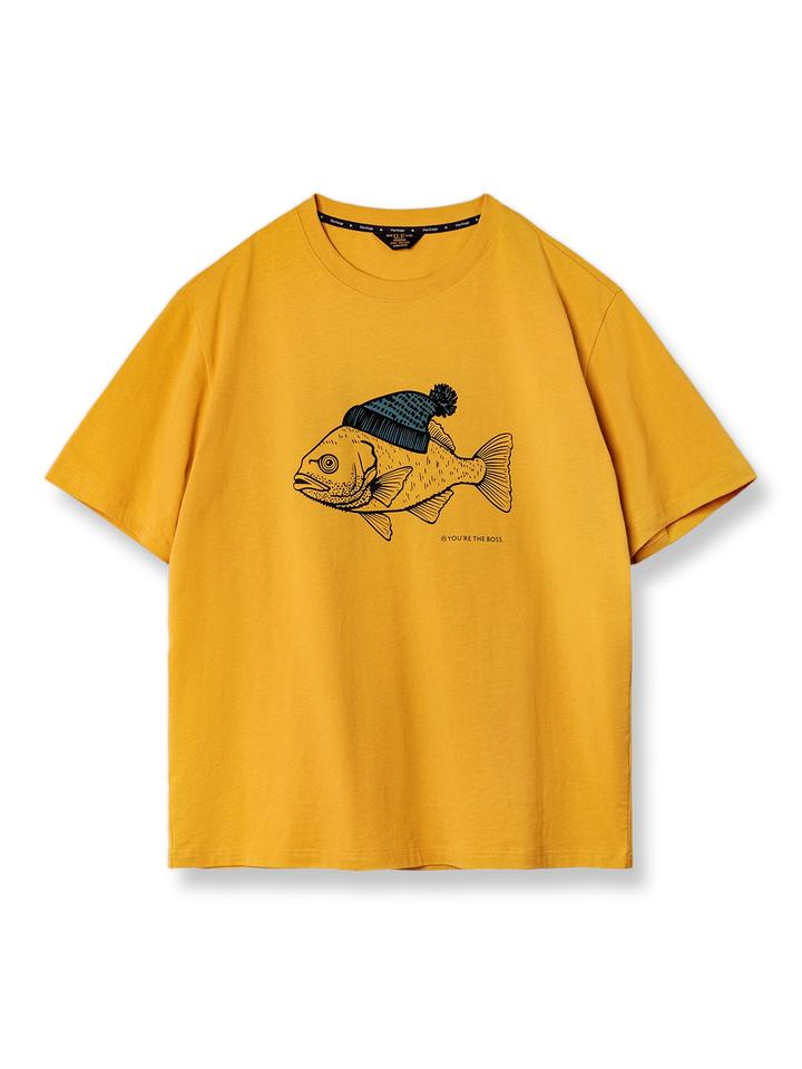 黄色の背景に帽子をかぶった深海魚のフロックプリントが施されたコットンTシャツの正面ビュー。しっかりした質感と優れた通気性を持つ純綿素材を使用しています。この代替テキストは、画像の内容を具体的に伝え、視覚情報にアクセスできないユーザーにも適しています。