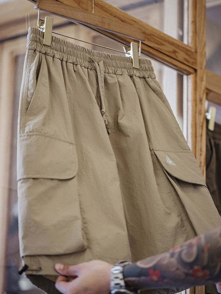 ショーツの多ポケットデザインとパンツ裾の伸縮性ドローコードのクローズアップ