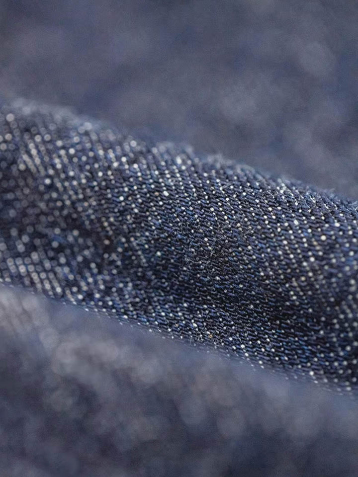 ディープブルー竹節デニムワークジャケットの細部のクローズアップ。140Zの高品質竹節デニムと粒状の質感が見える画像。