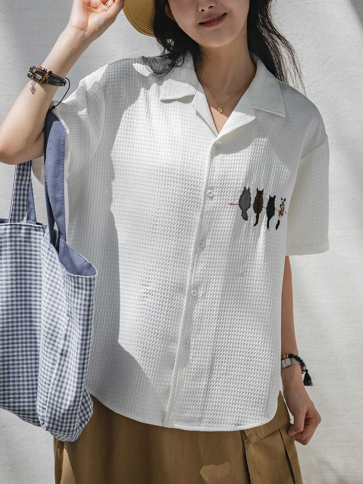モデルが夏のワッフルチェック キャット刺繍 オーバーサイズシャツを着用し、リラックスしたスタイリングを披露。