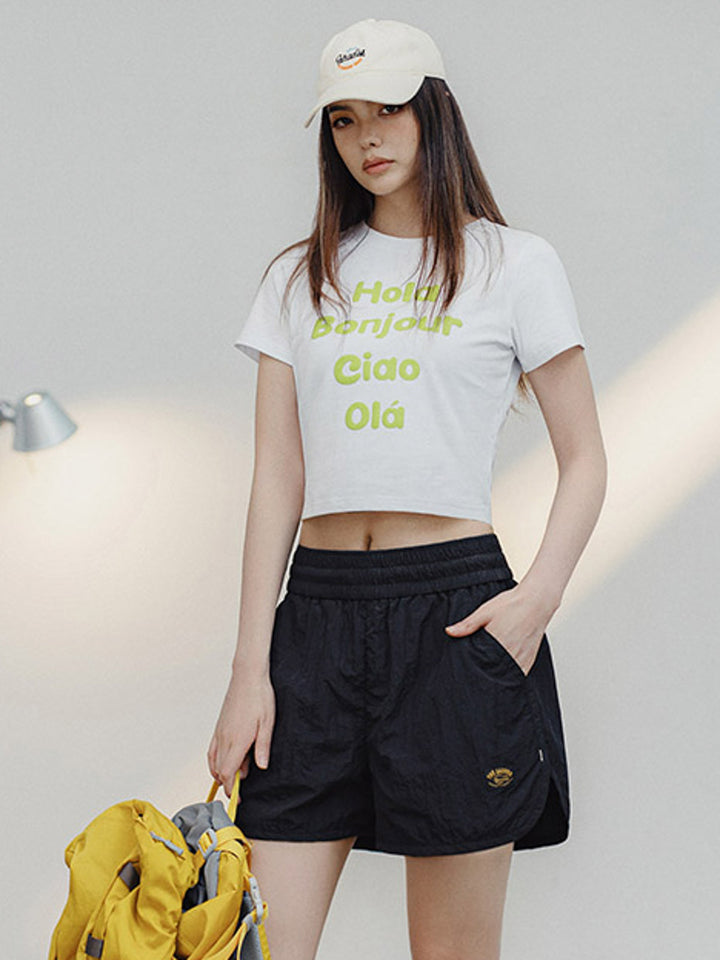 モデルがマルチランゲージプリントコットンTシャツを着用し、夏のカジュアルスタイルを披露