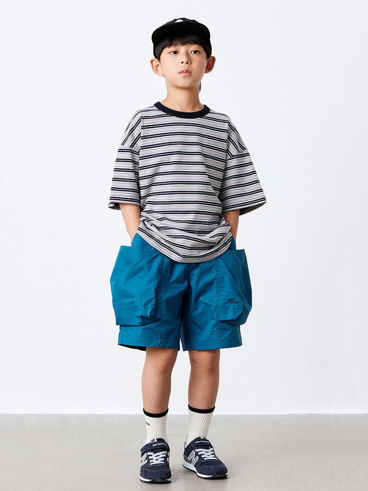 モデル画像：モデルが子供用立体ポケットワークショートパンツを着用し、ゆったりとしたデザインと全体のスタイルを展示。Tシャツとスニーカーを合わせています。