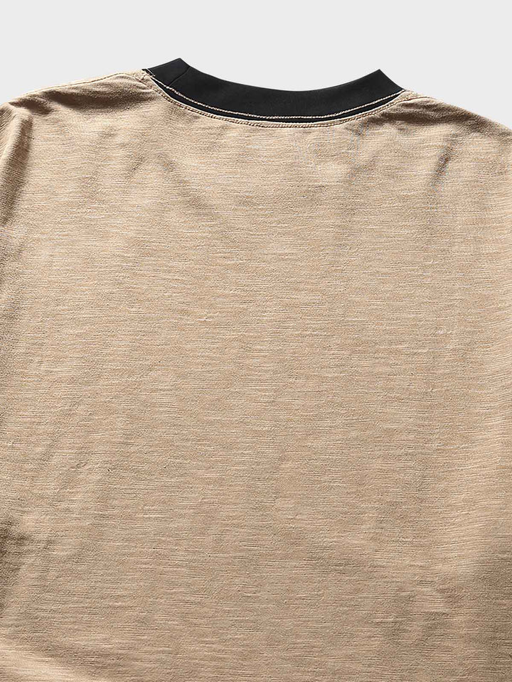 細部にわたるTシャツのラグランスリーブと袖口のコントラストデザイン。高品質なコットンとポリエステル素材のクローズアップ。