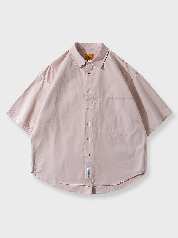 隠しポケットのディテールと精巧な縫製が見える半袖シャツのクローズアップ。
