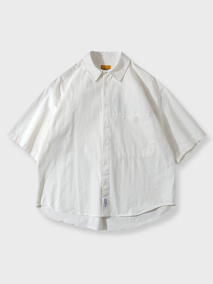 隠しポケットのディテールと精巧な縫製が見える半袖シャツのクローズアップ。
