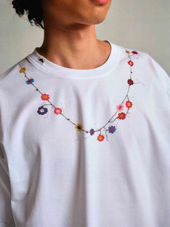 詳細画像: フラワーバッドネックレスTシャツの詳細図、精緻な花蕾刺繍とリブ付きクルーネックを展示