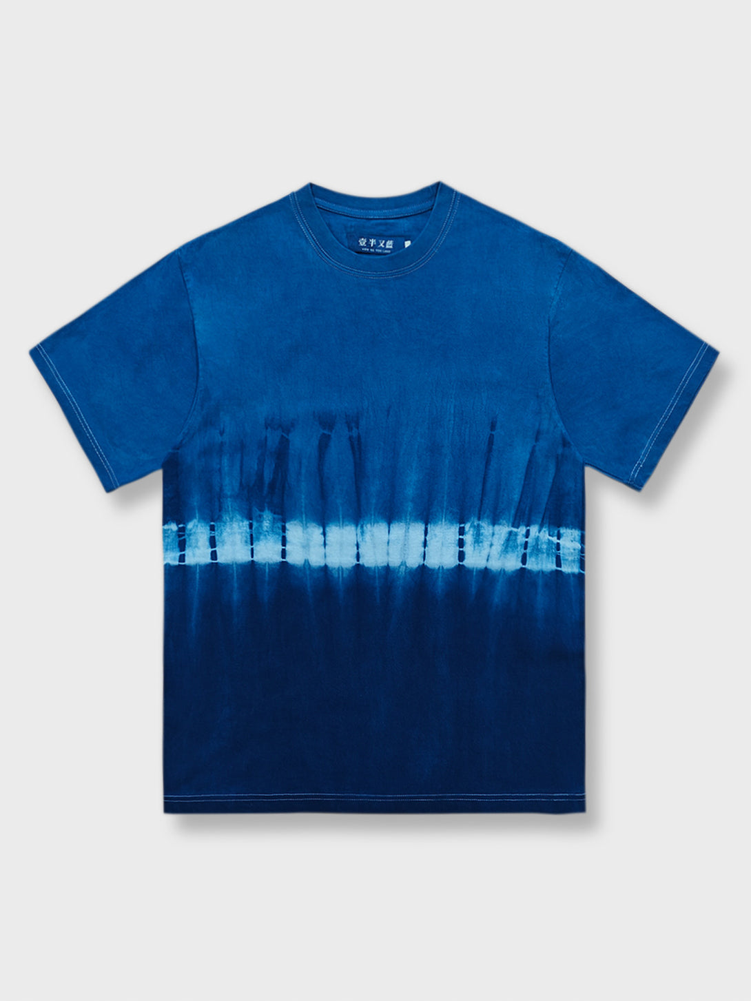 淡い色から濃い色へ変化する青のグラデーションを特徴とする絞り染めショートスリーブTシャツ。独特なアーティスティックな魅力があります。