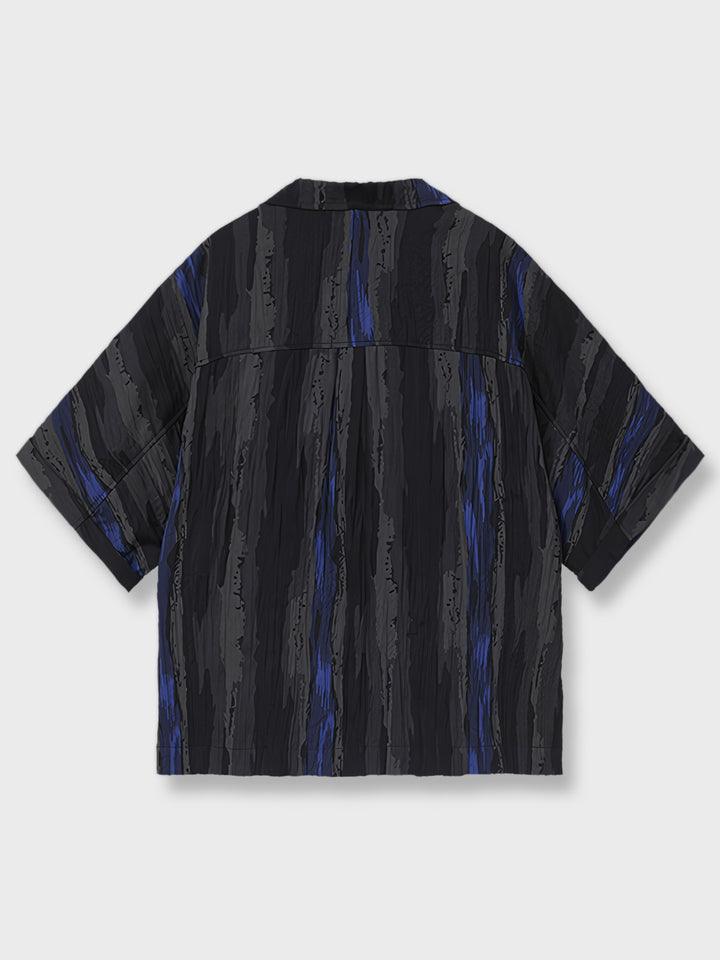 藍黒色の不規則な縦縞テクスチャーショートスリーブシャツ。モダンアートを思わせるデザインで、クラシックな要素を現代的に表現。