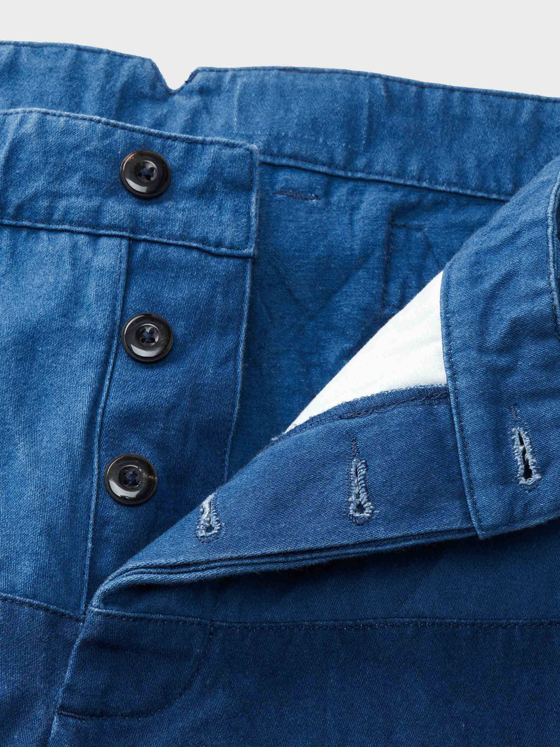 藍染め作業服パンツの後ろのウエストにあるクラシックなバックルバックのD型リングとポケットディテール